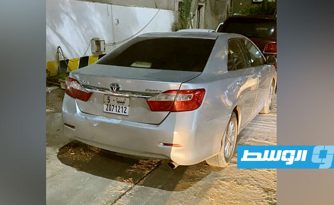 شرطي يقف بحوار إحدى السيارات المضبوطة (وزارة الداخلية بحكومة الدبيبة)