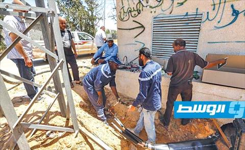 فريق صيانة بشركة الكهرباء يستبدل كوابل في محطة توزيع وسط العاصمة طرابلس، 25 يونيو 2020، (ا ف ب)