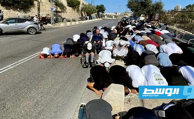 فلسطينيون يؤدون صلاة الجمعة قرب البلدة القديمة بعد منعهم من الوصول للمسجد الأقصى. (وفا)