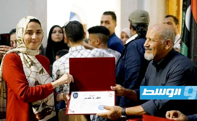 الفنان محمد الغرياني يسلم شهادة تقدير للفنانة عفراء الأشهب الفائزة بالمركز الأول للجائزة (فيسبوك)