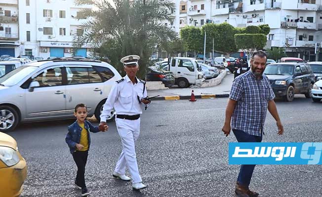 رجال المرور يساعدون تلاميذ المدارس في مرور الشوارع بالعاصمة طرابلس، 16 أكتوبر 2022. (مديرية أمن طرابلس)