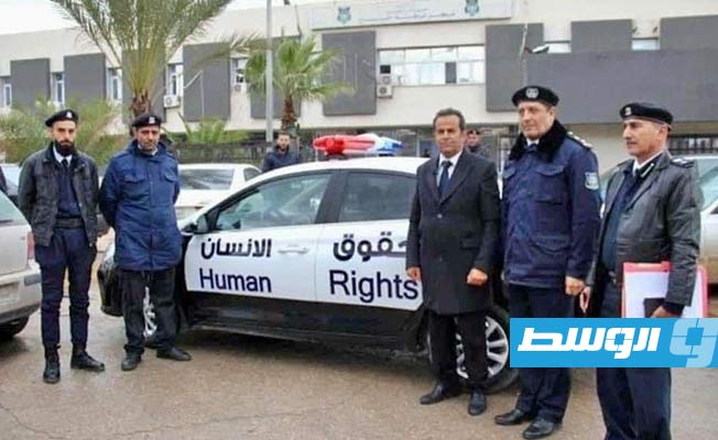 عدد من القيادات الأمنية جوار إحدى سيارات مكتب شؤون حقوق الإنسان في منطقة الفرناج.