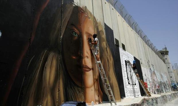 عهد التميمي على جدار الفصل الإسرائيلي قبل الإفراج عنها