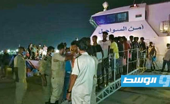 المهاجرون لدى إنزالهم في ميناء طرابلس البحري.