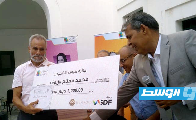 الروائي محمد الزروق يتسلم الجائزة التشجيعية (بوابة الوسط)