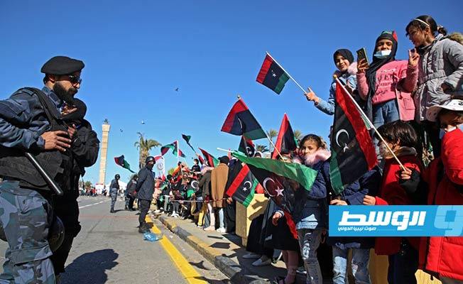 ليبيون يلوحون بالأعلام أثناء تجمعهم في ميدان الشهداء بالعاصمة طرابلس للاحتفال بذكرى ثورة فبراير، 17 فبراير 2021. (أ ف ب)
