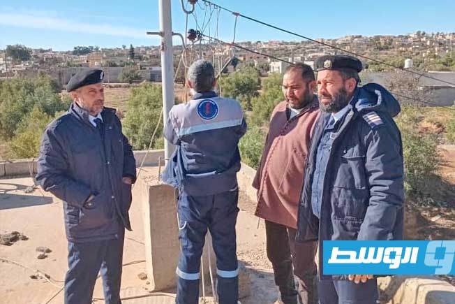 أفراد مركزا الشرطة الكهربائية مزدة وغريان، التابعان لفرع الجبل الغربي، أثناء تنفيذ أعمال قطع التوصيلات غير القانونية داخل مدينة الأصابعة. (الإدارة العامة للشرطة الكهربائية)