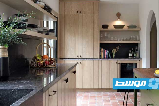 تصميم أنيق يدمج الجرانيت مع الخزائن الخشبية. (موقع هومز آند غاردنز)