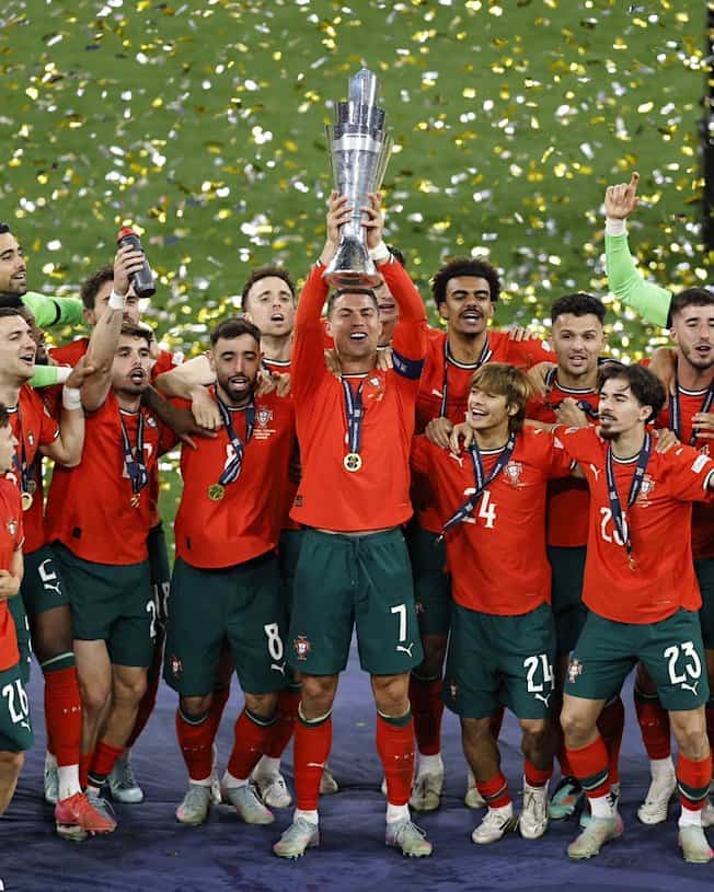 لاعبو منتخب البرتغال يحتفلون على منصة التتويج بلقب دوري الأمم الأوروبية 2025 على ملعب «أليانز أرينا» بمدينة ميونخ الألمانية، الأحد 8 يونيو 2025. (منصة أكس)