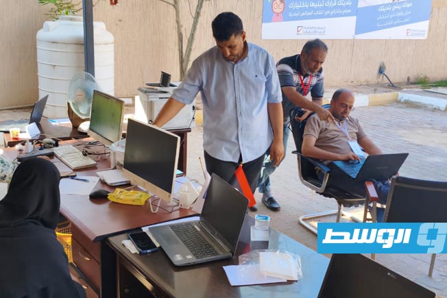 موظفون في مكتب الإدارة الانتخابية بالساحل الغربي يؤدون عملهم بانتخابات البلديات بالمكتب الذي تعرض لحريق فجر أمس (مفوضية الانتخابات)