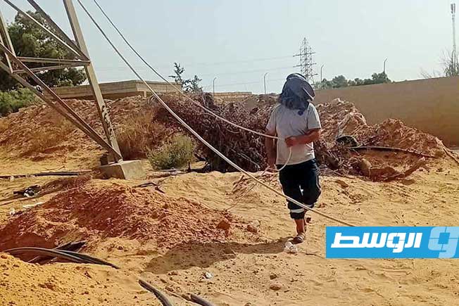 موظف يحتمي من حرارة الشمس أثناء العمل في ربط كابلات كهرباء بالزاوية، 13 سبتمبر 2025 (الشركة العامة للكهرباء)