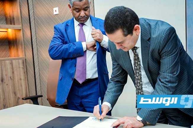 عبالهادي الحويج والقنصل السوداني يوقعان على تسليم واستلام جوازات عدد من أفراد الجالية السودانية في بنغازي، الجمعة 12 ديسمبر 2025. (وزارة الخارجية والتعاون الدولي بالحكومة المكلفة من مجلس النواب)