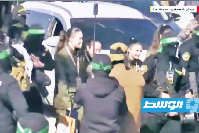 من تسليم المقاومة الفلسطينية 4 مجندات إسرائيليات في ميدان فلسطين في غزة. 25 يناير 2025. (صورة مثبتة من فيديو)