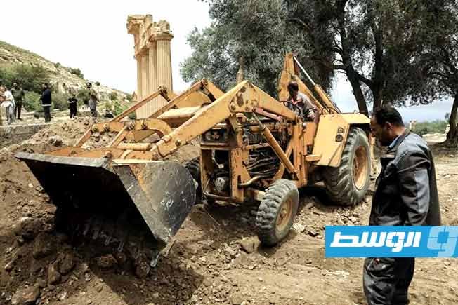 يقوم عمّال وعلماء آثار بأعمال الحفر والحفاظ في الموقع الأثري في قورينا، بالقرب من بلدة شحات على الساحل الشمالي الشرقي لليبيا، في 18 مايو 2026. (أ ف ب)