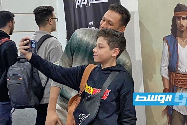 البخاري يتلقط الصور بمعرض الكتاب مع الجمهور (فيسبوك)