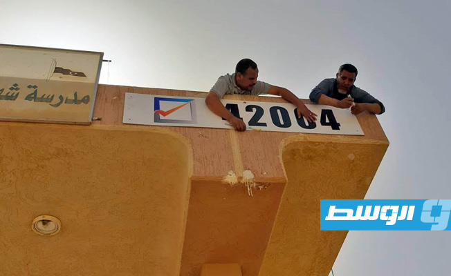 تركيب لوحات أرقام مراكز الانتخاب على واجهات المدارس التي جرى تخصيصها لإجراء عملية الاقتراع. (مفوضية الانتخابات)