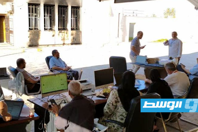 موظفون في مكتب الإدارة الانتخابية بالساحل الغربي يؤدون عملهم بانتخابات البلديات بالمكتب الذي تعرض لحريق فجر أمس (مفوضية الانتخابات)