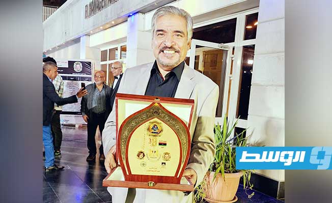 عبدالباسط الجارد يحمل درع التكريم (خاص لـ بوابة الوسط)