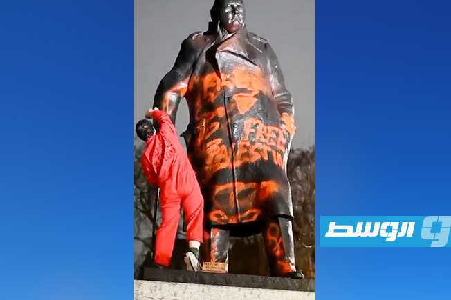 صورة للناشط الهولندي وهو يرش تمثال تشرشل بالشعارات المناهضة للإبادة الجماعية في غزة. (ديلي ميل)
