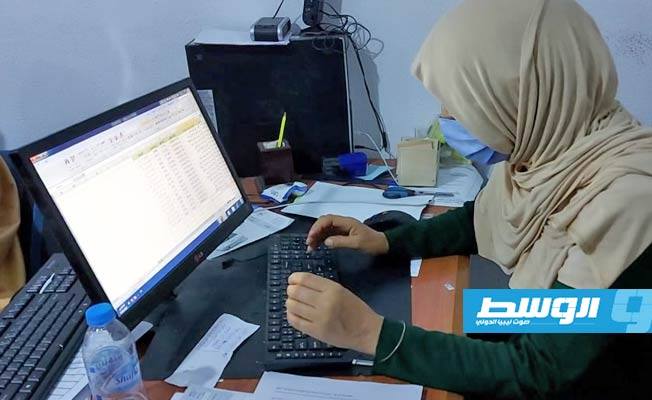 موظفة بالشؤون الاجتماعية تقوم بإدخال بيانات المواطنين الخاصة بعلاوة الأسرة في بني وليد. (الإنترنت)