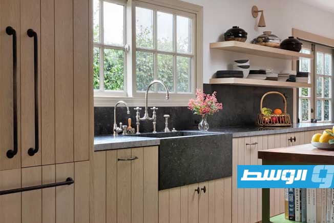 تصميم أنيق يدمج الجرانيت مع الخزائن الخشبية. (موقع هومز آند غاردنز)