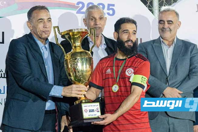 قائد فريق الأحرار بزليتين يتسلم كأس البطولة (تصوير - محمد قجام)