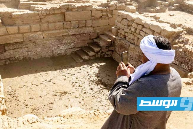 عامل مصري أمام البحرة المكتشفة في مجمع الكرنك بالأقصر جنوب مصر. (السفارة الصينية في مصر على فيسبوك)
