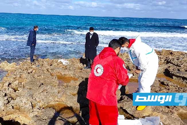 فريق الهلال الأحمر أثناء انتشال الجثة من شاطئ البحر بمنطقة الحمامة شمال مدينة البيضاء. (جمعية الهلال الأحمر فرع الساحل)