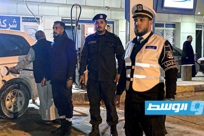 رجال أمن يحاولون تنظيم سير الحركة في محطة وقود بأجدابيا (مديرية أمن أجدابيا)