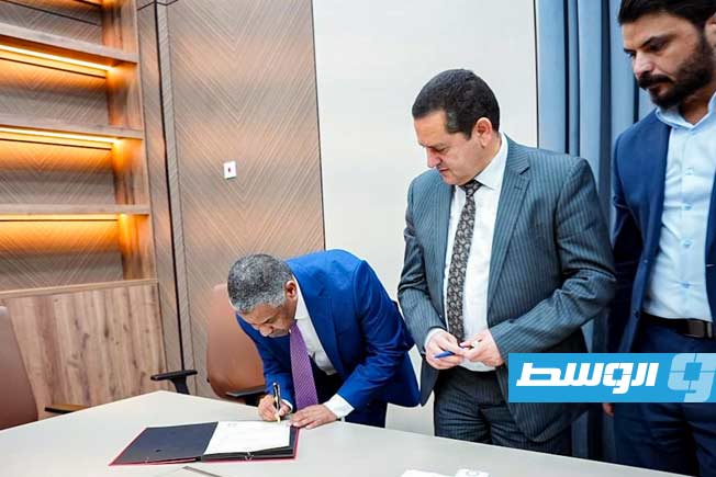 عبالهادي الحويج والقنصل السوداني يوقعان على تسليم واستلام جوازات عدد من أفراد الجالية السودانية في بنغازي، الجمعة 12 ديسمبر 2025. (وزارة الخارجية والتعاون الدولي بالحكومة المكلفة من مجلس النواب)