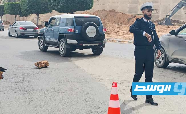 شرطي ينظم المرور بجوار هبوط أرضي بطريق الجامعة، 7 ديسمبر 2023. (مديرية أمن طرابلس)