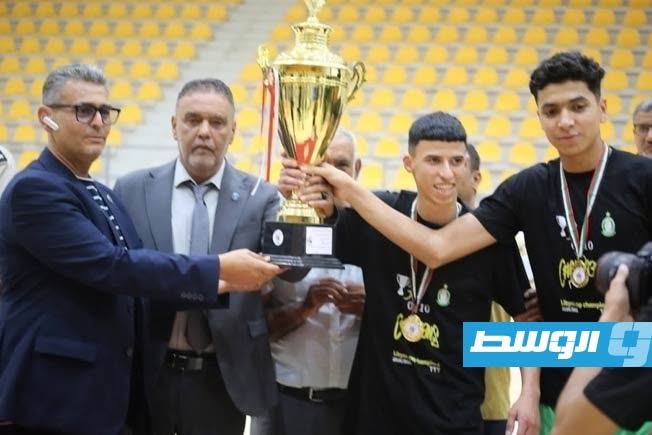 لاعبو فريق أواسط الأهلي طرابلس يتسلمون كأس بطولة ليبيا لكرة اليد (فيسبوك)