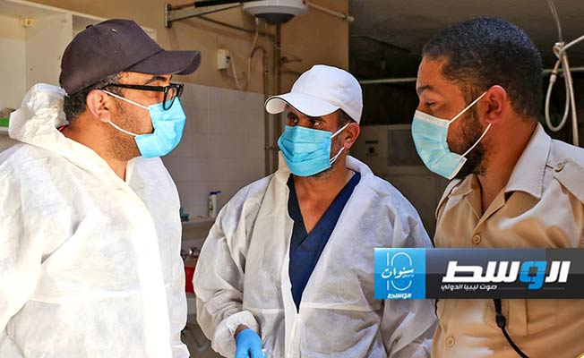 فرق هيئة البحث والتعرف على المفقودين خلال أخذ عينات الحمض النووي من جثتين بمستشفى غدامس العام. (صفحة الهيئة على فيسبوك)